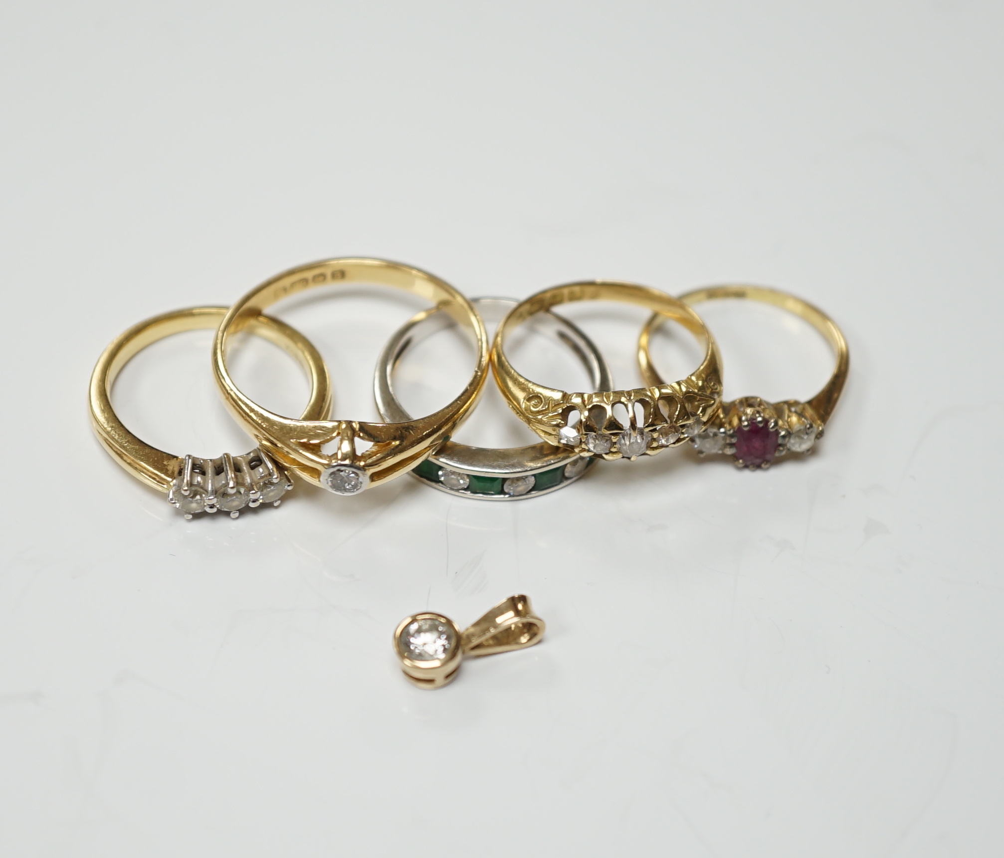 Four assorted early 20th century and later 18ct and gem set rings, including solitaire diamond and three stone diamond, gross 14.6 grams, together with a white metal and channel set emerald and diamond half hoop ring and